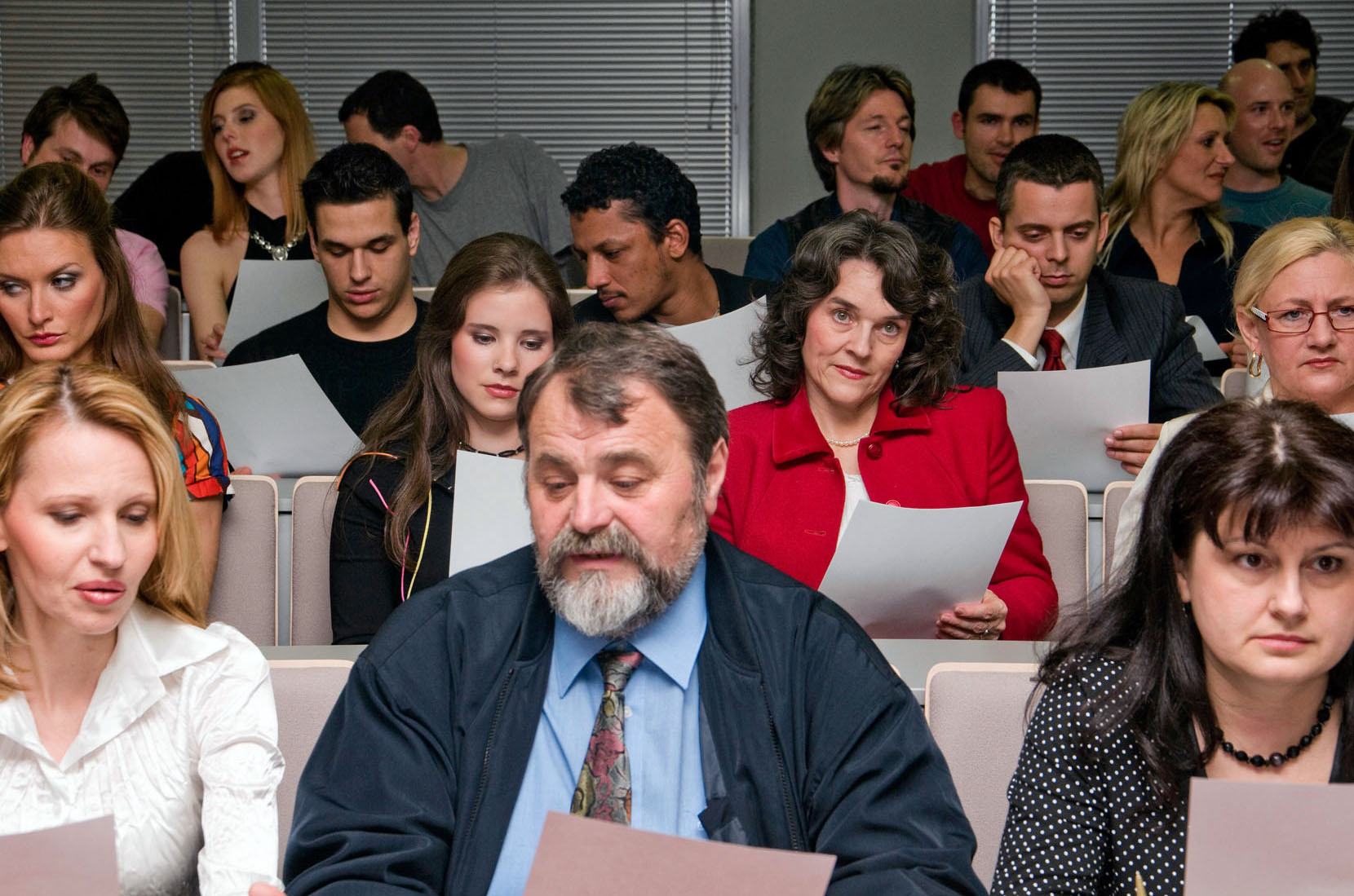 Adult Learners Seated in Classroom Reading Paper